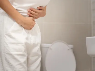 a woman experiencing digestive discomfort in a bathroom
