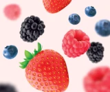 Photo d’une douzaine de petits fruits mélangés (fraises, bleuets, framboises et mûres) flottant sur un fond rose pâle pour mettre en valeur le goût délicieux et les arômes naturels des Soft Chews Kids