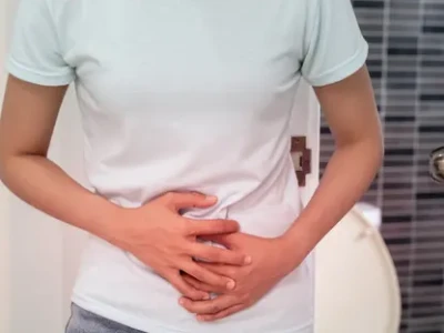 man sitting uneasily, struggling with constipation while on travel