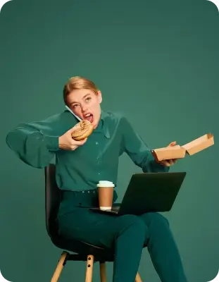 Person multitasking by talking on phone, eating a bagel, and using a laptop, with coffee on lap.
