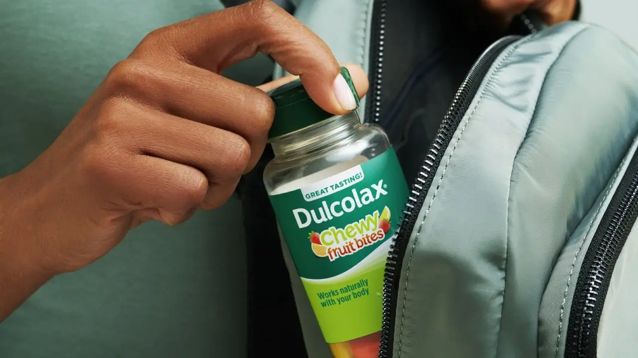 Elderly man running through a forest, wearing a green shirt and a smartwatch.