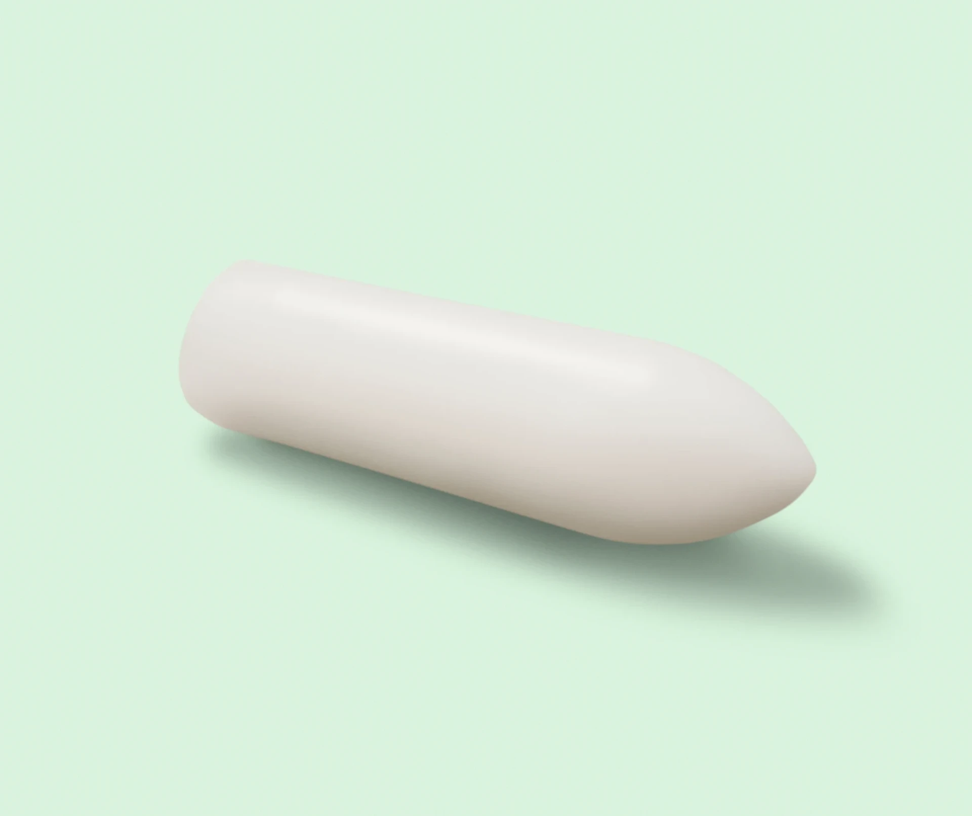 Photograph of a DulcoLax Suppository laying on a light green background
