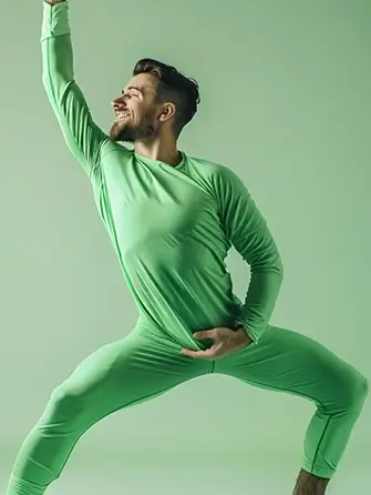 Man in a green outfit striking a dynamic pose against a green background.